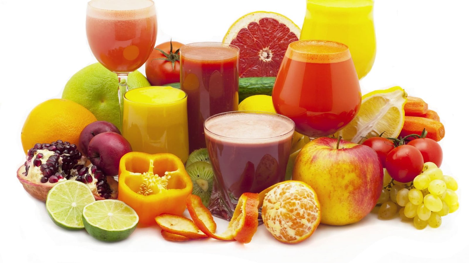 alt="Conjunto de jugos naturales en copas finas, rodeado de frutas y verduras de variuos colores, y algunas casacaras de frutas, todo en tono rojo, amarillo y verdes"