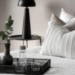 alt="Una habitacion tranquilla llena de paz, una cama arreglada con dos amohadas bien comodas, tonos blancos y grises"