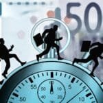 alt="Un billete de dinero de 500 Euros de fondo, en frente un reloj enorme y encima caminando figuras de holmbres con maletas, caminan de prisa"