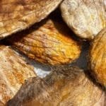 alt="VArias semillas de mango apiladas, de color marron amarillento porque etan deshidratadas"