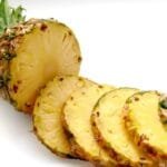 alt="Piña cortada en rodajas sobre fondo Blanco"
