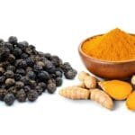 alt="cúrcuma en polvo y en raiz al lado de Pimienta negra, fondo blanco"