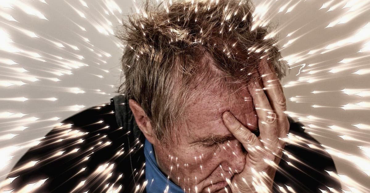 alt="La mano cubriendo la mitad del rostro de hombre de edad de 65 años, parenta dolr o precupacion, destelloz de luz en toda la imagen