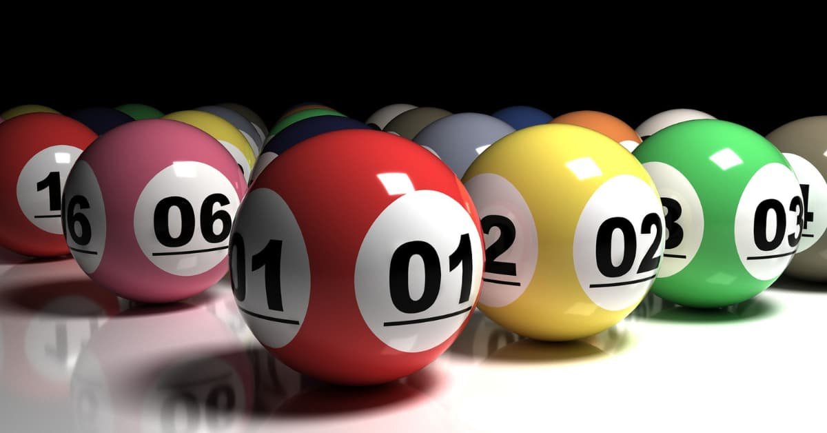 alt="Bolas de lotería numeradas en colores vibrantes sobre fondo oscuro"