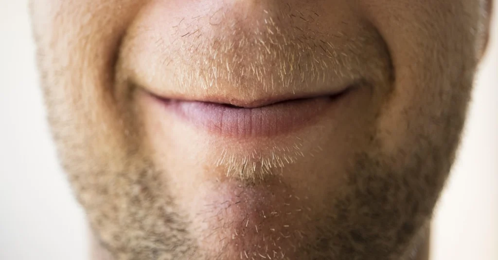 alt="Sonrrisa malvada en la cara de un hombre con barba"